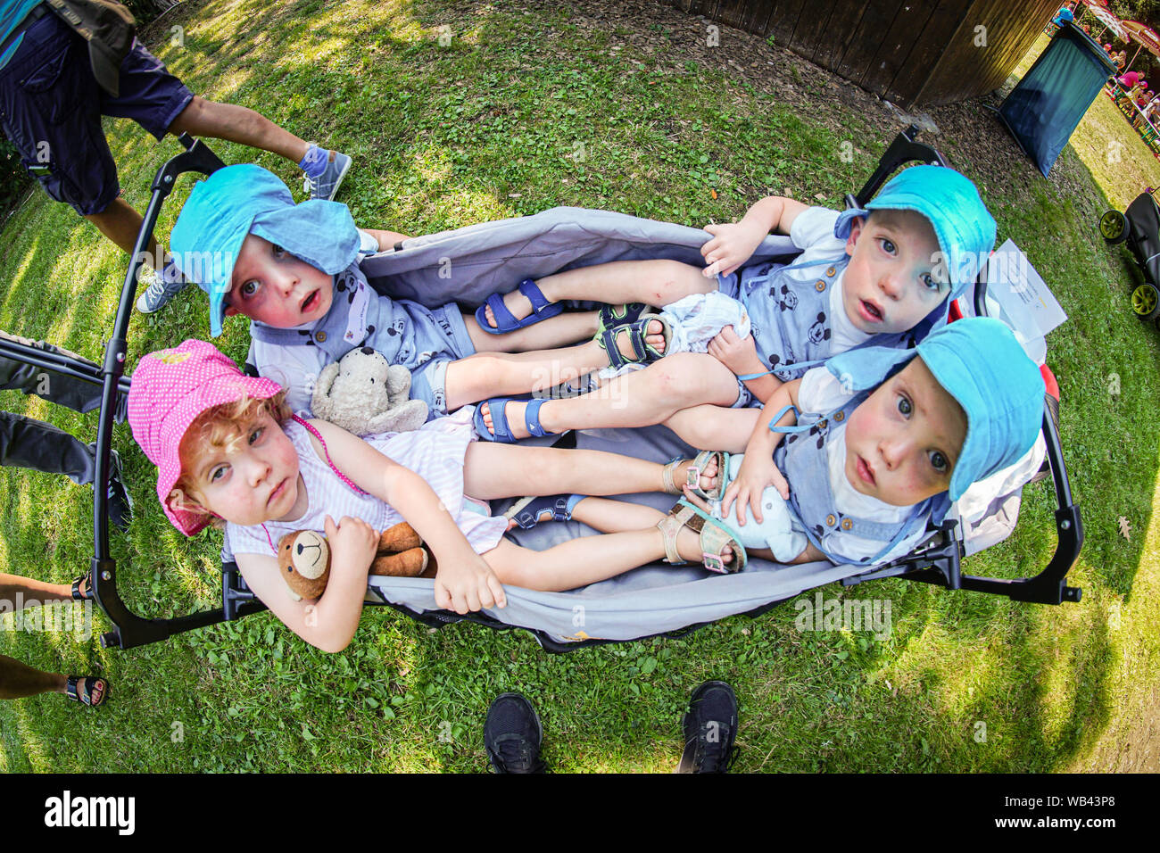24 August 2019, Hessen, Lich: The two-year-old quadruplets Maja (l-r), Bruno, Paul, Oskar from Giessen sit in their little cart at the triplet meeting of the Hessian Prime Minister. In Hesse, the traditional head of government takes over the honorary sponsorships until the children start school. Photo: Frank Rumpenhorst/dpa Stock Photo