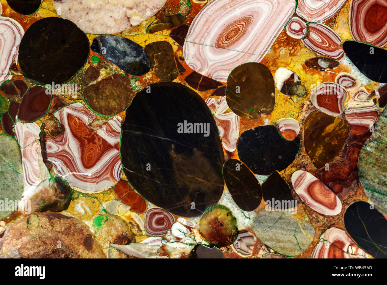 background - a natural multi-colored stone, a conglomerate of jasper and agate Stock Photo