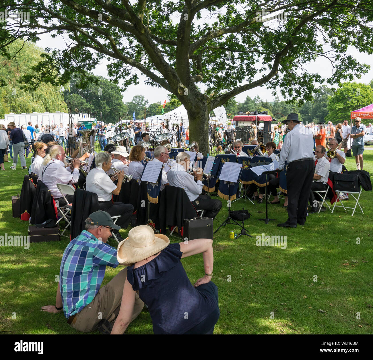 The Suffolk Phoenix Brass Band playing in shade of tree at The Helmingham Festival of Classic & Sports Cars 2019 Stock Photo