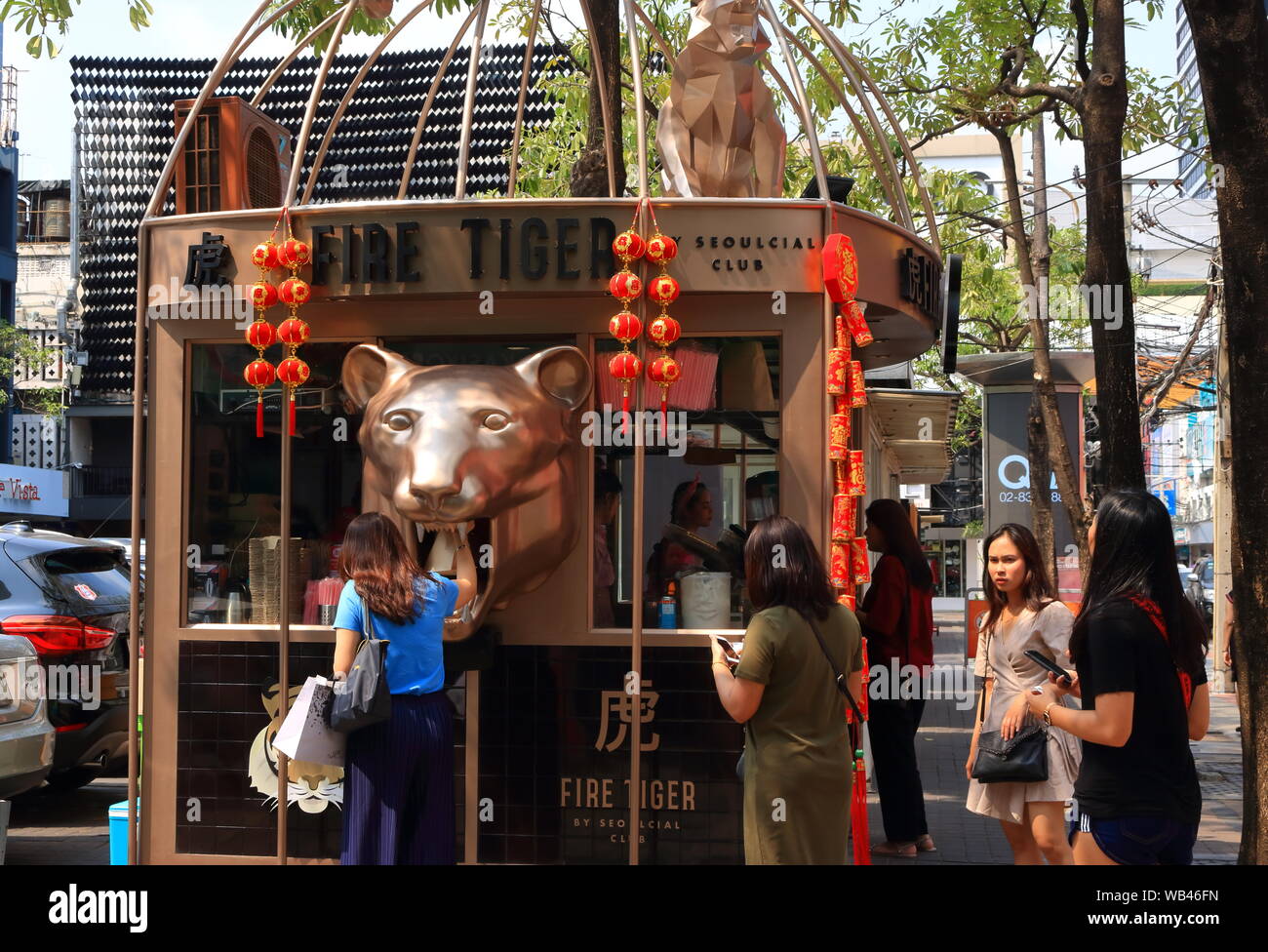 A lady is picking up her drink from tiger mouth of fire tiger, which is a refreshment stall in siam square shopping center, Bangkok, Thailand Stock Photo