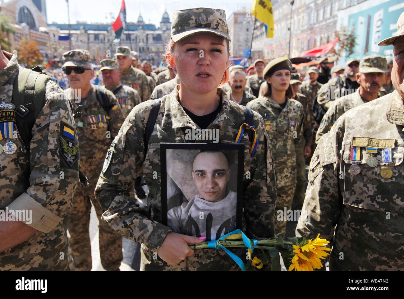 A Ukrainian servicewoman holds a veteran's portrait at the Independence Square during the Anniversary.Ukraine marks the 28th Independence Day Anniversary from the Soviet Union since 1991 on August 24, 2019. Stock Photo