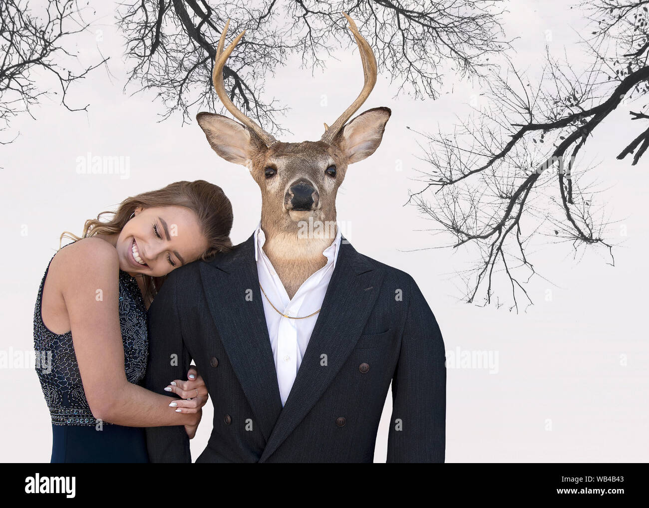smiling teenage girl and big buck wearing a tuxedo on tree branch background Stock Photo