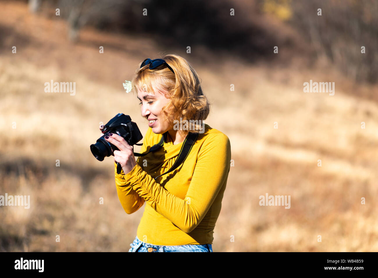 Female photographer capturing autumn scenery outdoors Stock Photo