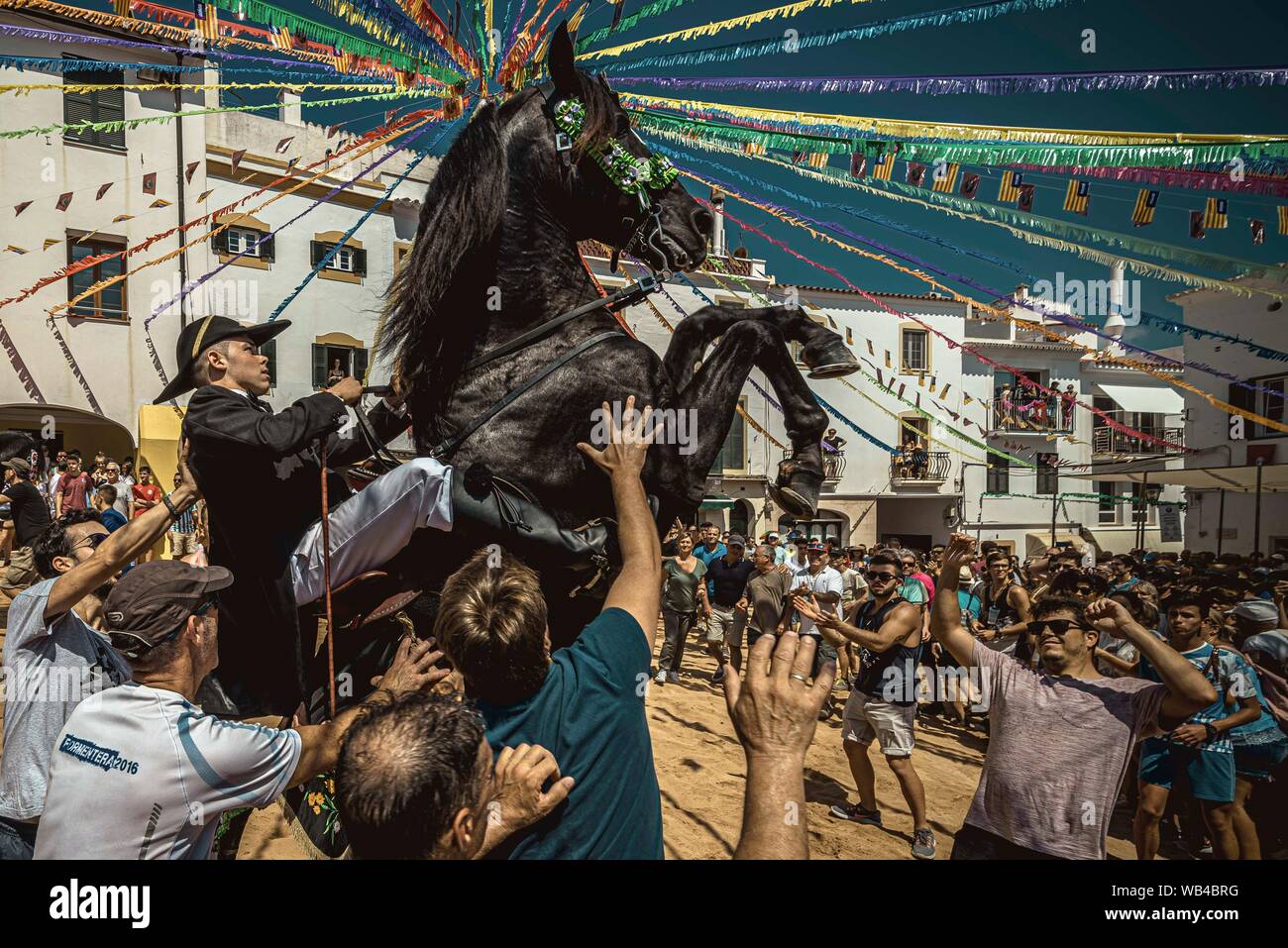 Ferreries, Spain. 24th Aug, 2019. A 'caixer' (horse rider) rears up on his horse surrounded by a cheering crowd during the traditional 'Jaleo' at the Sant Bartomeu Festival in Ferreries. Credit: Matthias Oesterle/Alamy Live News Stock Photo