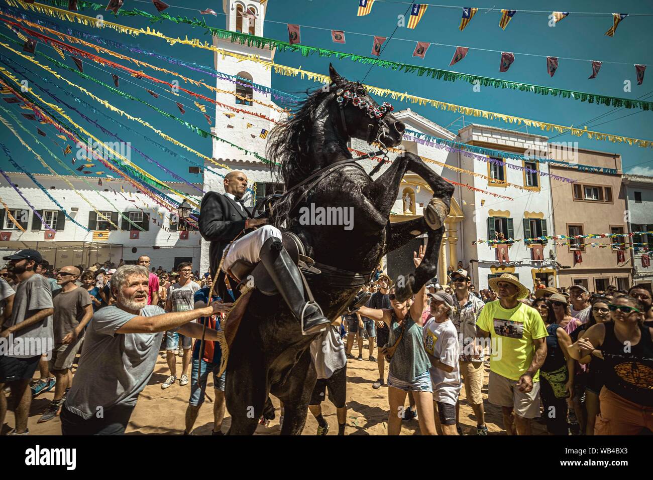 Ferreries, Spain. 24th Aug, 2019. A 'caixer' (horse rider) rears up on his horse surrounded by a cheering crowd during the traditional 'Jaleo' at the Sant Bartomeu Festival in Ferreries. Credit: Matthias Oesterle/Alamy Live News Stock Photo