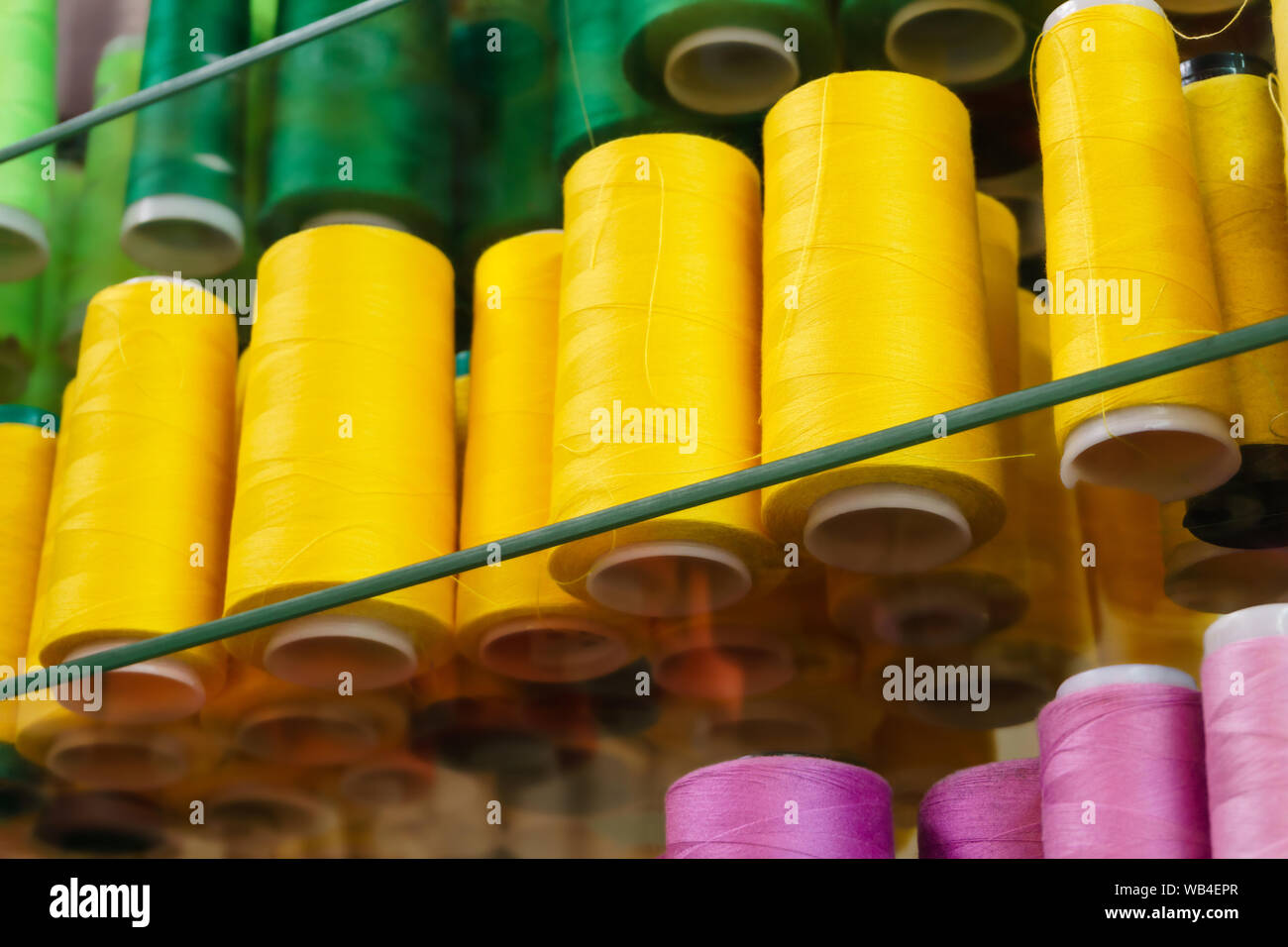industrial bobbins with colored sewing threads on glass shelves Stock ...