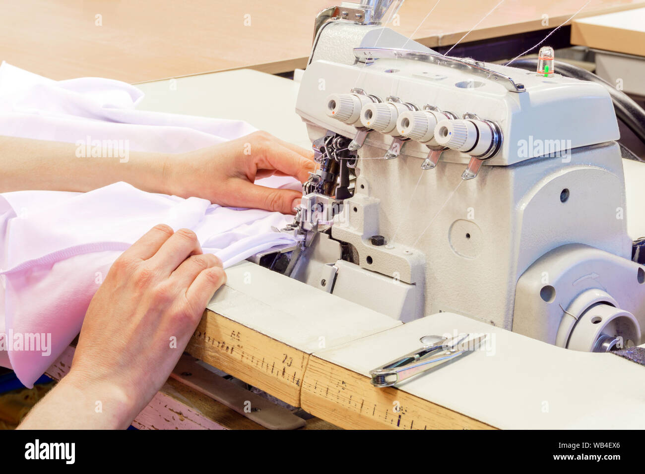 industrial overlock sewing machine and hands of seamstress at work in the  garment factory Stock Photo - Alamy