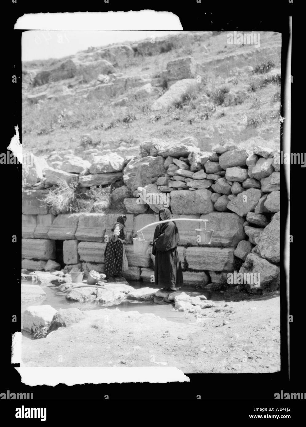 East of the Jordan and the Dead Sea. Circassian women at fountain, Jerash Abstract/medium: G. Eric and Edith Matson Photograph Collection Stock Photo