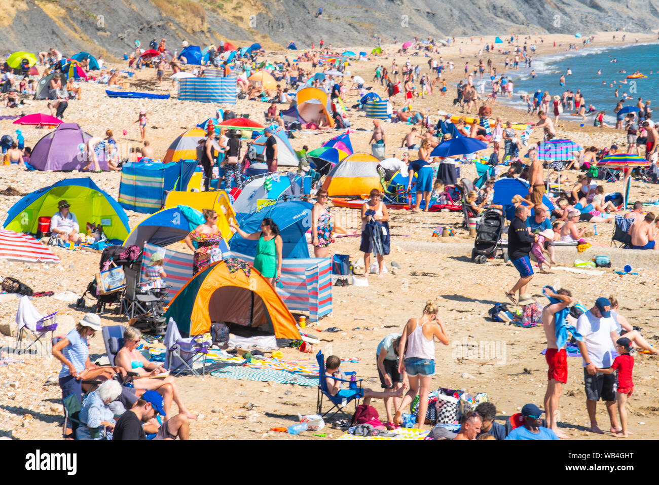 Charmouth, Dorset, UK. 24th Aug, 2019. UK Weather: The seaside village of Charmouth (Lyme Regis' quieter neighbour) was busy as sun seekers flocked to the beach to soak up the hot sunshine over the August bank holiday weekend. Credit: Celia McMahon/Alamy Live News Stock Photo