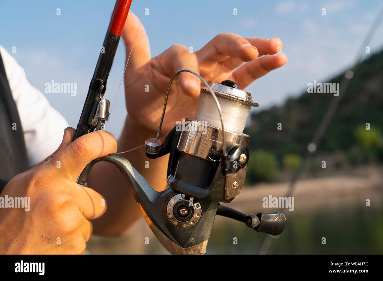 Male hand holding fishing rod and getting ready to hook Stock