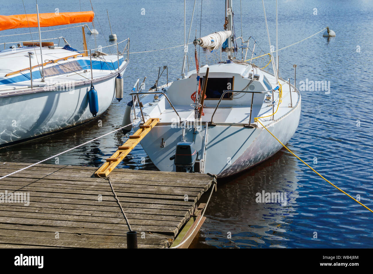 two small sailboats moored at a wooden pier Stock Photo - Alamy