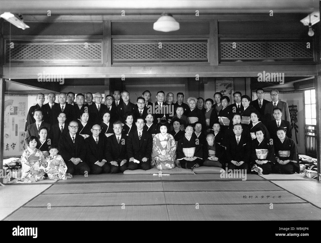 [ 1930s Japan - Group Portrait at Japanese Wedding ] —   Family group photo at a wedding. The majority of the men wear Western style suits, while all the women wear kimono.  By the 1920s, Japanese wedding customs had undergone a great transformation due to Western influences. This is clearly visible in this photo.  20th century vintage gelatin silver print. Stock Photo