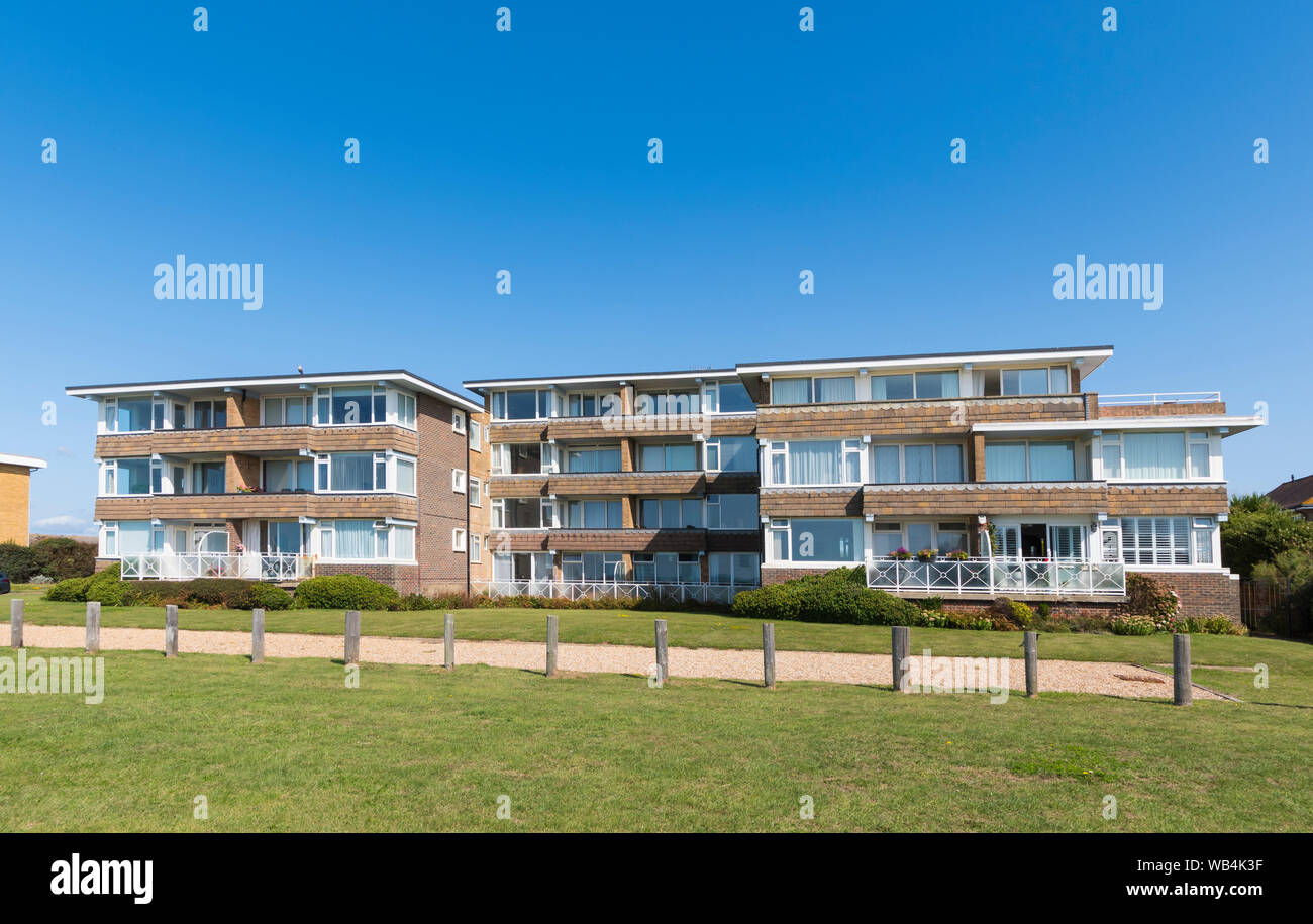 Modern seafront flats (apartment block) with 3 and 4 storeys overlooking green area in Rustington. West Sussex, England, UK. Stock Photo
