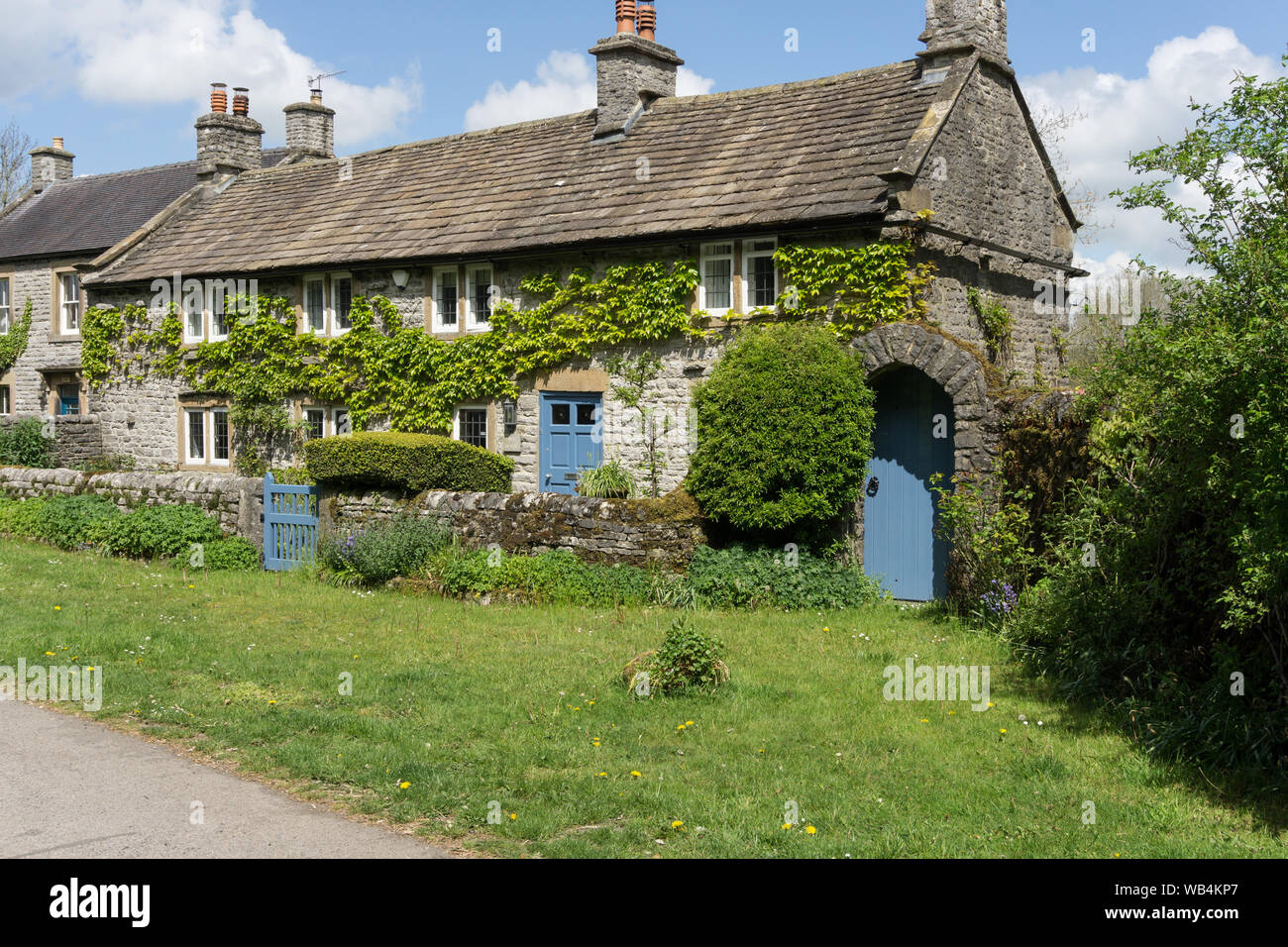 Stone built detached house, with creeper clad wall, in the village of