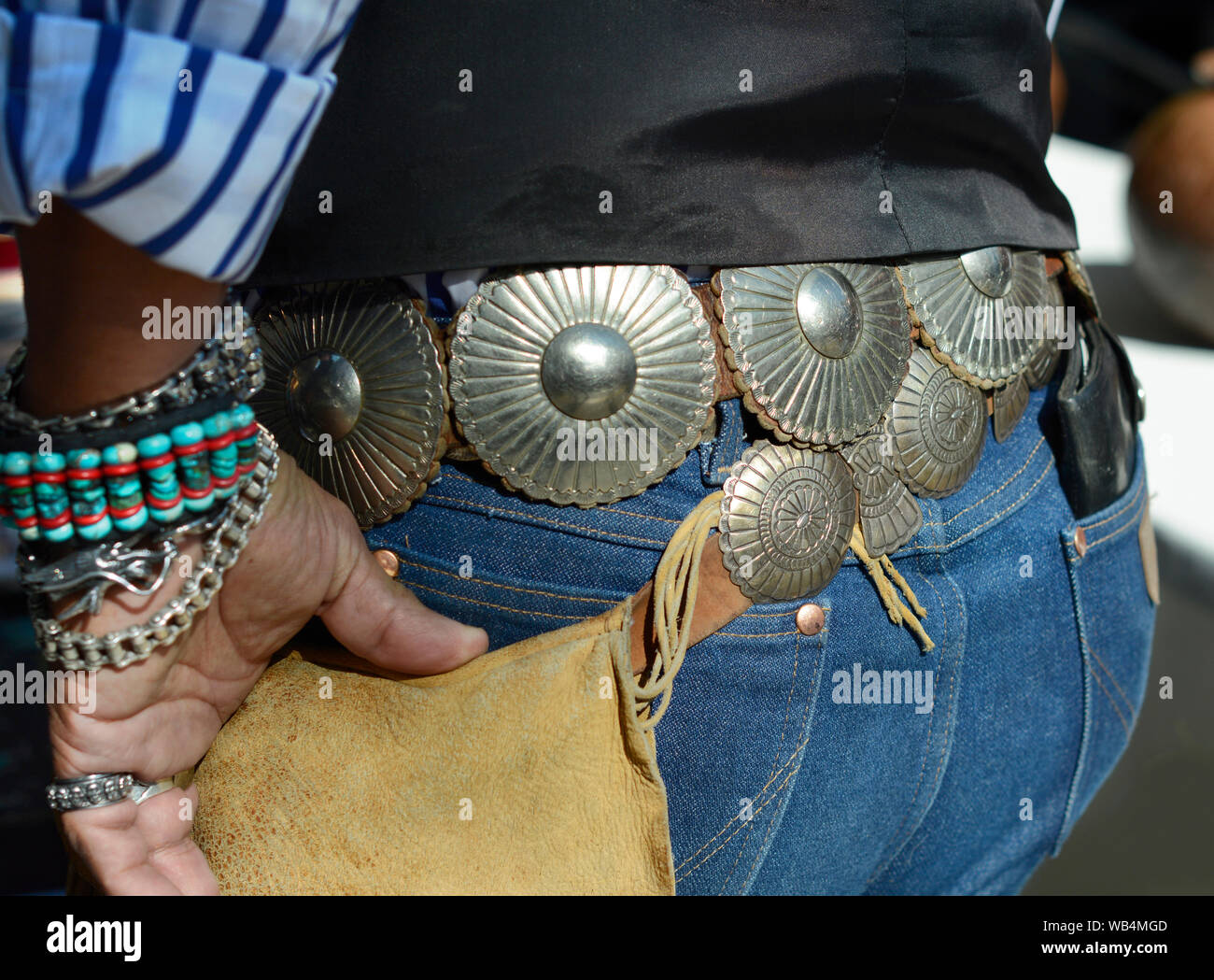 A man wearing western style attire including a concho belt visits the Santa Fe Indian Market in New Mexico, USA Stock Photo