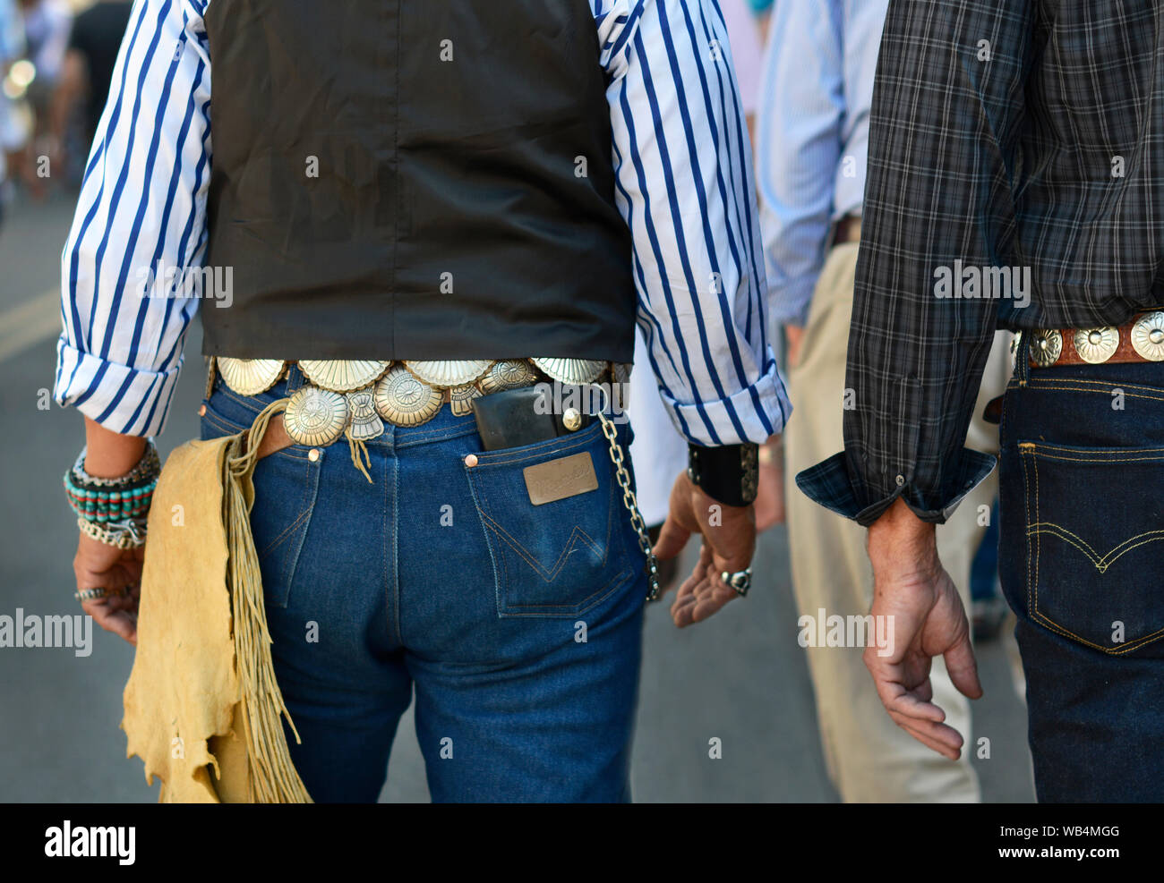 Two men wearing western style attire including concho belts visit the Santa Fe Indian Market in New Mexico, USA Stock Photo