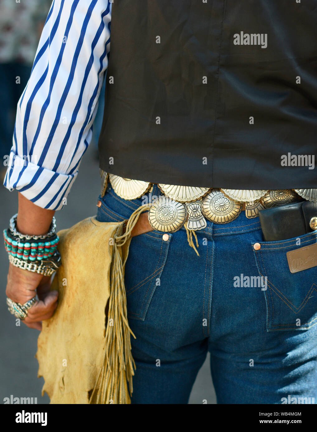 A man wearing western style attire including a concho belt visits the Santa Fe Indian Market in New Mexico, USA Stock Photo