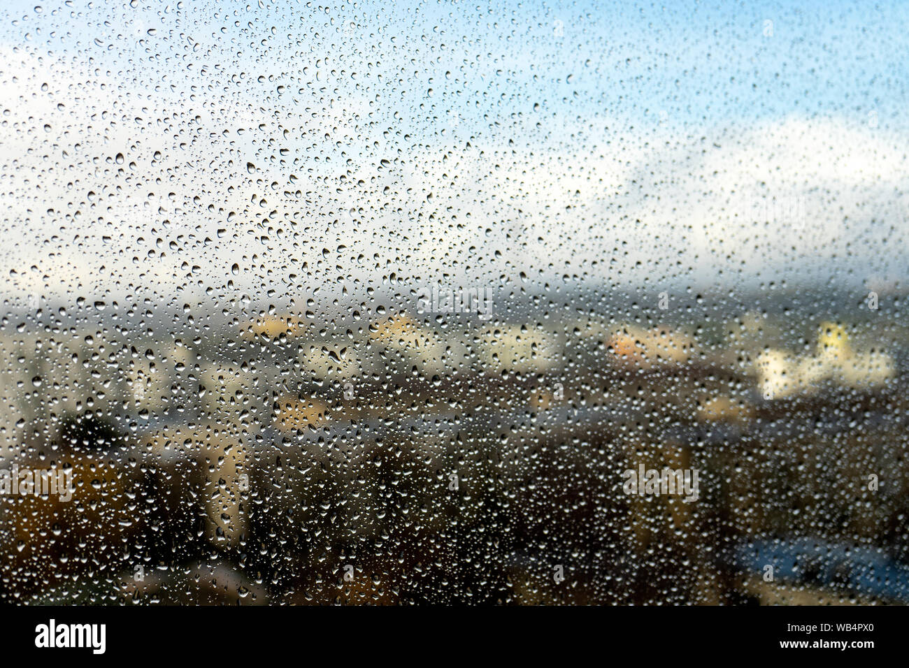 Raindrops on the window. Landscape through the humid glass. Metaphor of bad mood, depression and sadness Stock Photo