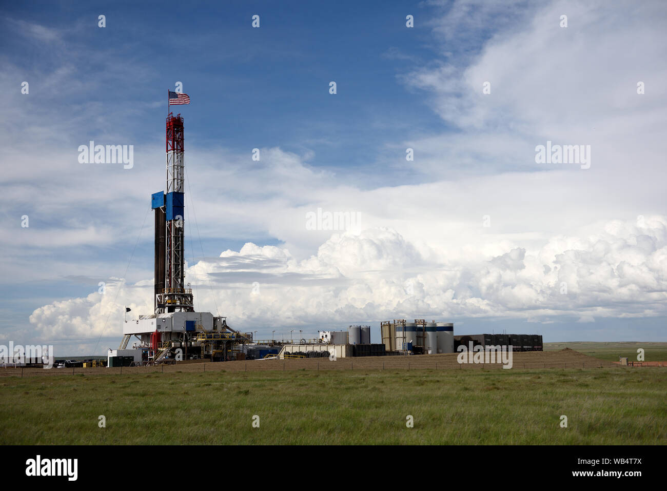 Crude oil exploration well site and drilling rig with clouds and sky in the Powder River Basin