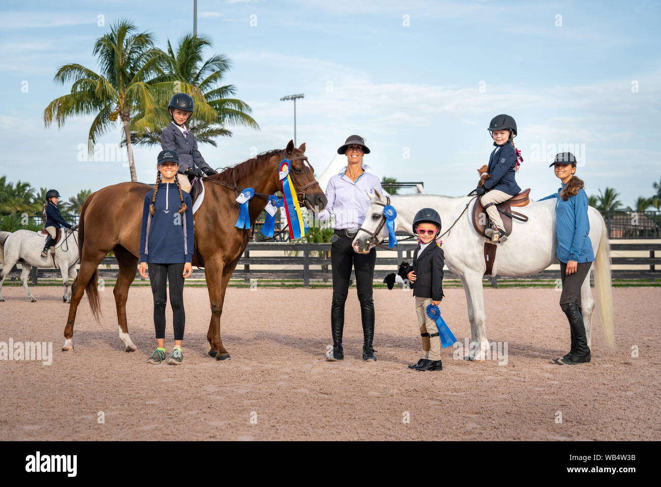 A female equestrian coach and her riding students and working students