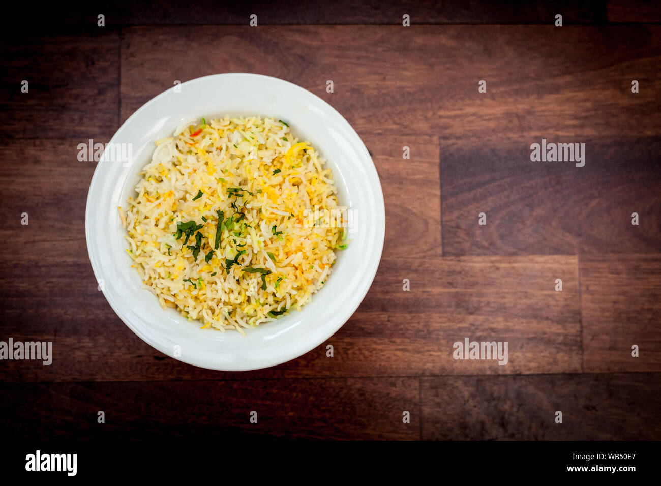 Bowl of pilau rice on wooden background Stock Photo