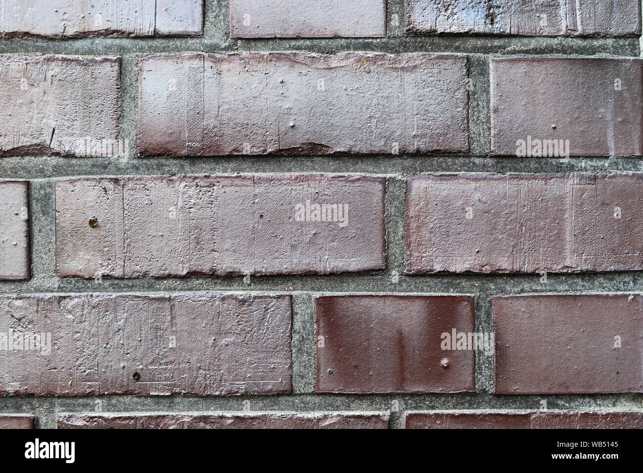 Detailed close up view on an aged and weathered red brick wall texture ...