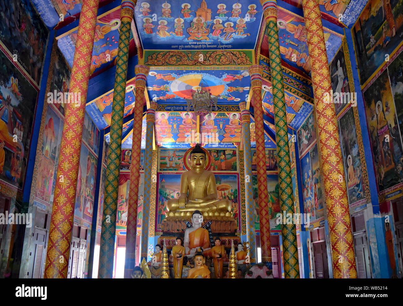 Colorful Buddhist temple interior colonnade and altar with Buddha