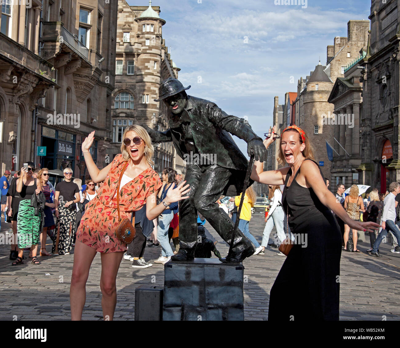 Edinburgh Fringe Festival, Royal Mile, Scotland, UK. 24th Aug, 2019. On this last very hot Saturday of the 2019 Fringe, Kevin the human statue who is normally very dour comes to life to pose with two attractive ladies, must be the heat. Stock Photo