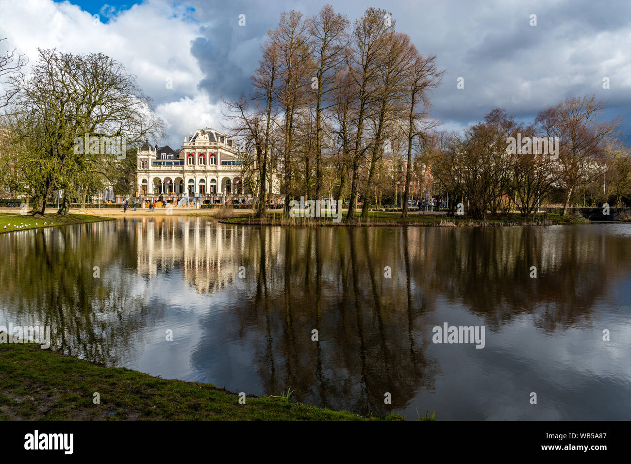View over the water in Amsterdam Vondelpark during autumn on a bright day reflecting trees in the water Stock Photo