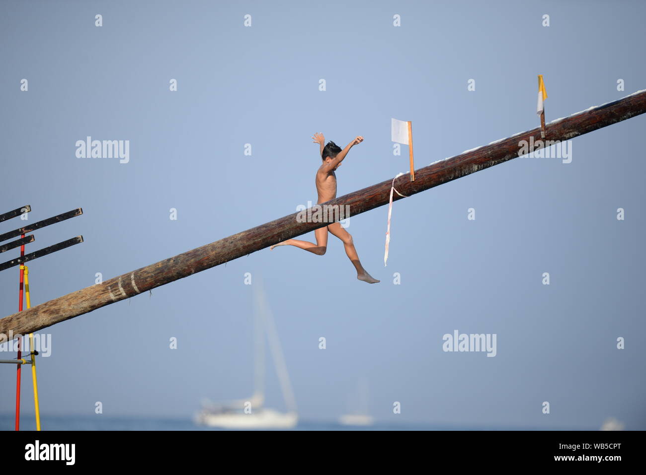 A participant during the greasy pole ('Ġostra' in Maltese) event at the village feast in St Julians, Malta Stock Photo
