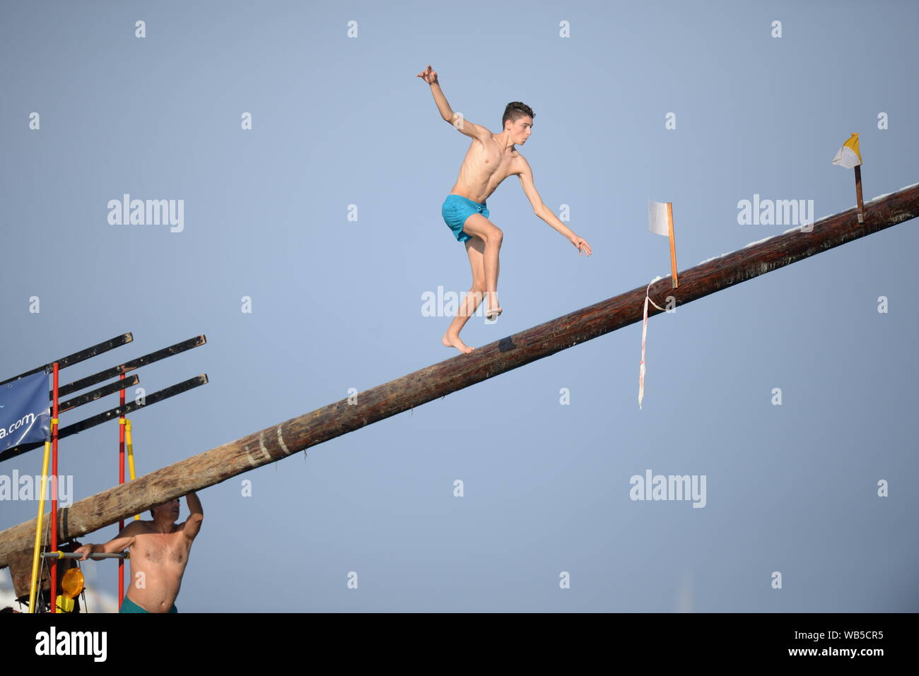 A participant during the greasy pole ('Ġostra' in Maltese) event at the village feast in St Julians, Malta Stock Photo