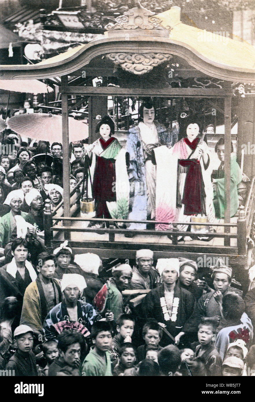 [ 1890s Japan - Performers at a Japanese Festival ] —   Three costumed performers on a stage of what appears to be a danjiri (float) perform a dance during a matsuri (religious festival).  Albumen photograph sourced by Kozaburo Tamamura (1856-1923?), 1890s, for 'Japan, Described and Illustrated by the Japanese', Shogun Edition edited by Captain F Brinkley. Published in 1897 by J B Millet Company, Boston Massachusetts, USA.  19th century vintage albumen photograph. Stock Photo