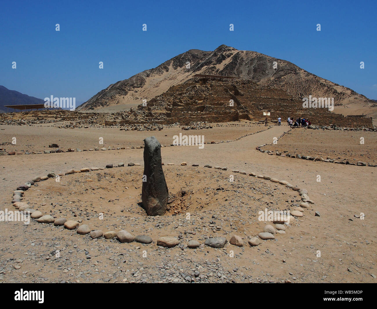 Monolith and pyramid of the ancient sacred city of Caral as part of the celebrations for the 24th anniversary of the beginning of the research work. The sacred city of Caral is considered as the oldest civilization in America, its remains date from 3,500 BC. Stock Photo