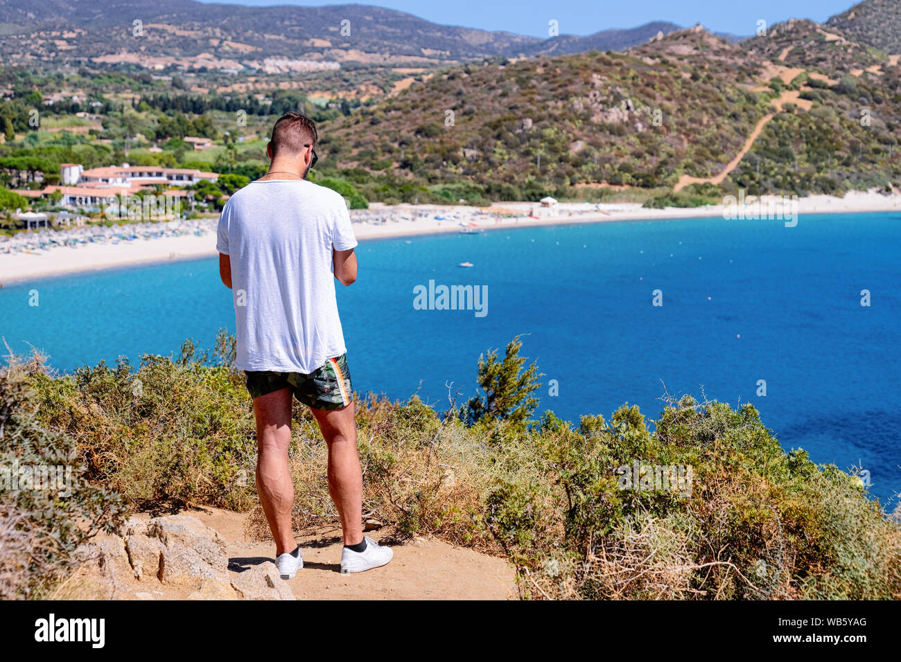 Man looking at beach near Mediterranean Sea in Villasimius in Sardinia Island in Cagliari in Italy in summer. View on Sardinian beach in Sardegna. Stock Photo