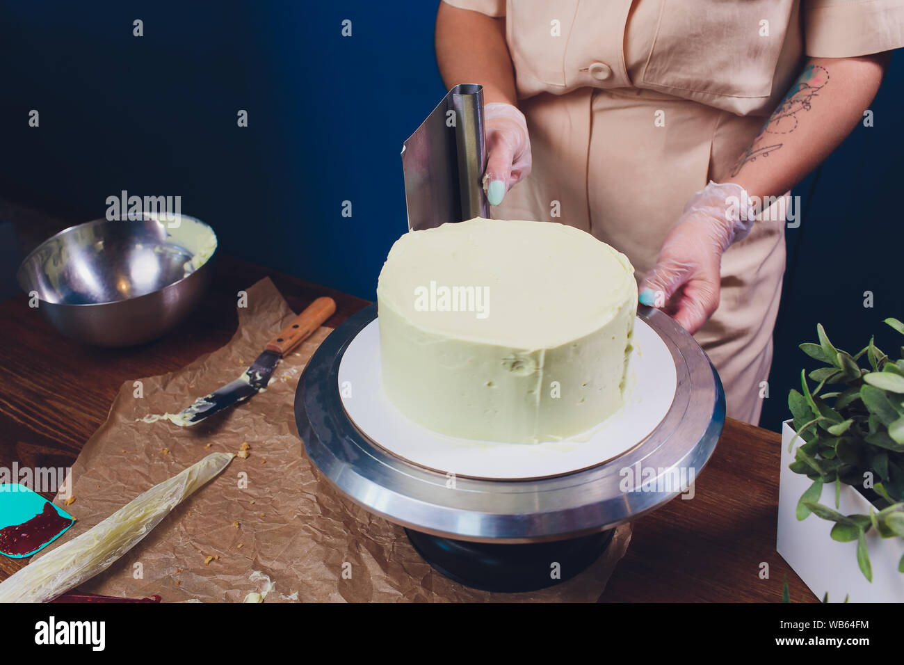 women's hands making biscuit cake with white cream using a cooking ...