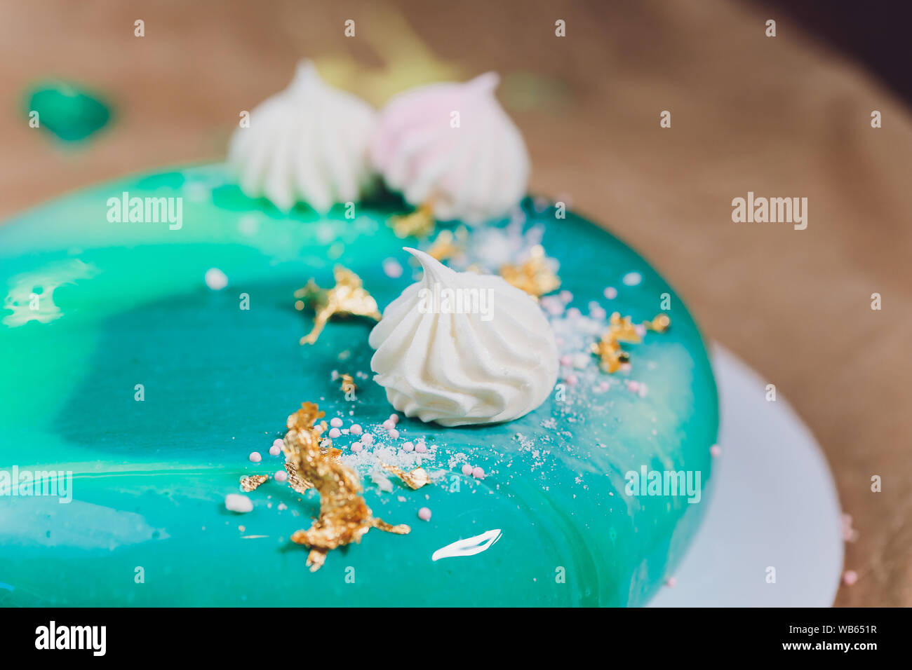 Close-up eating slice of mousse cake covered blue and green mirror glaze.  French dessert. Frozen mirror icing on the cake. Baking and confectionery  co Stock Photo - Alamy