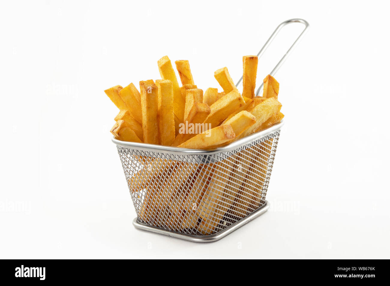 Pommes frites dans un panier en métal sur la table de cuisine blanche. Mise au point sélective Stock Photo
