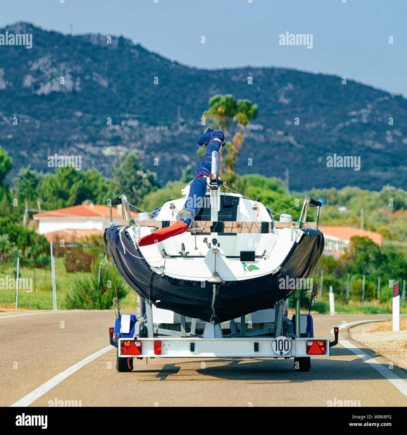 Car with yacht or motor boat on the road of Costa Smeralda in Sardinia in Italy in summer. Auto
