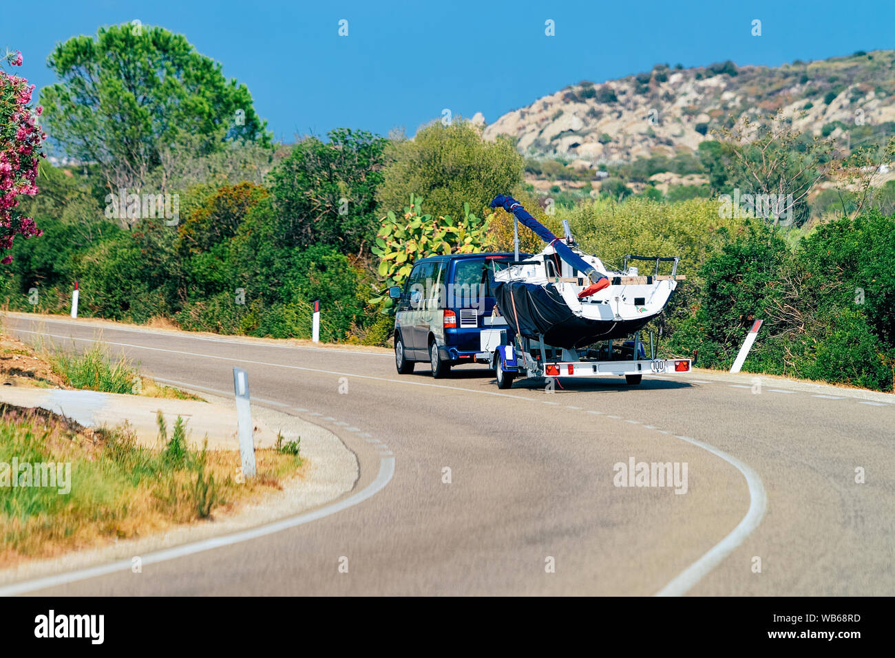 Car with yacht or motor boat in the road of Costa Smeralda in Sardinia in Italy in summer. Auto