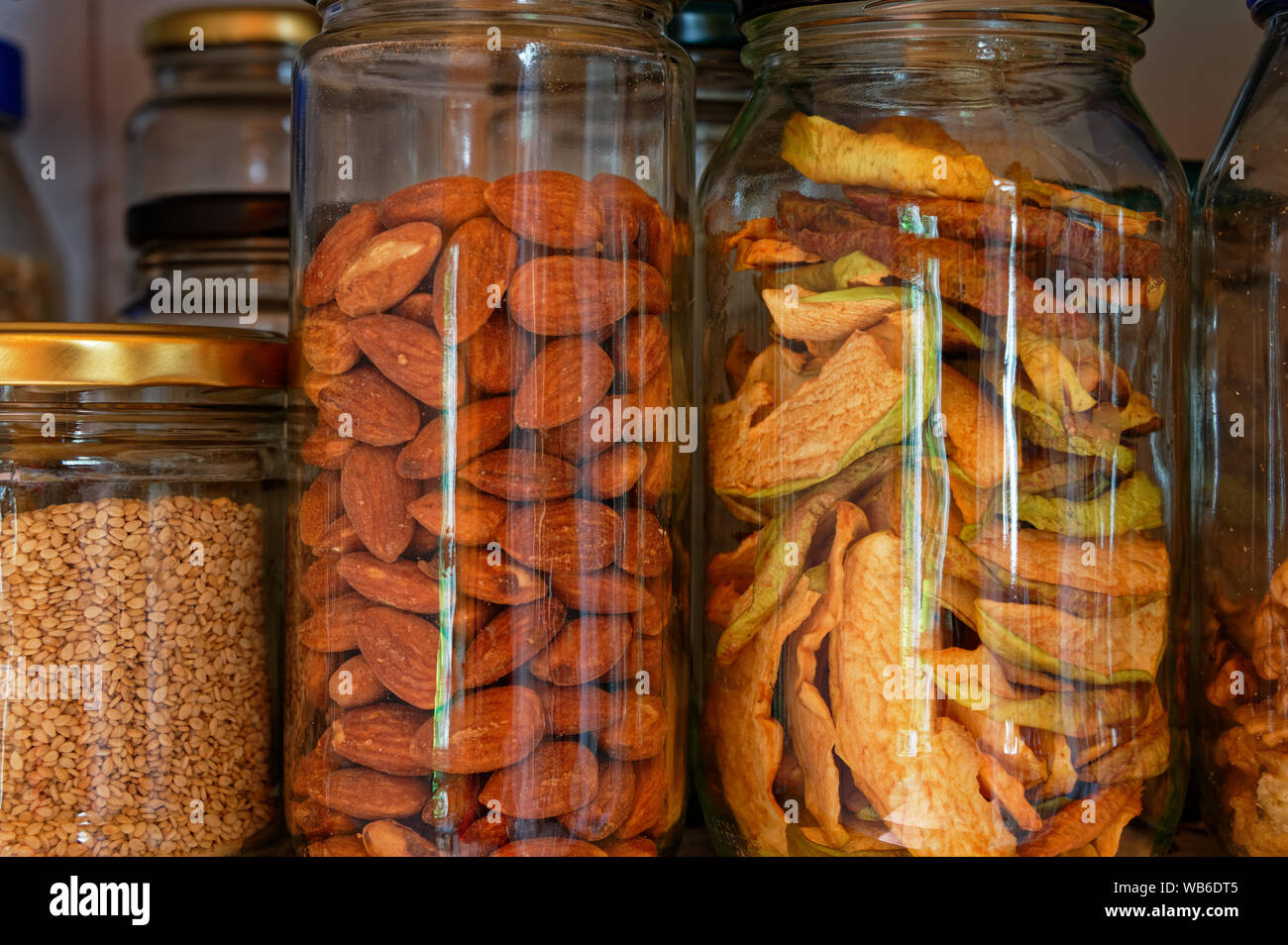 Almonds and dried apple slices stored in glass jars, reducing the use of plastic Stock Photo