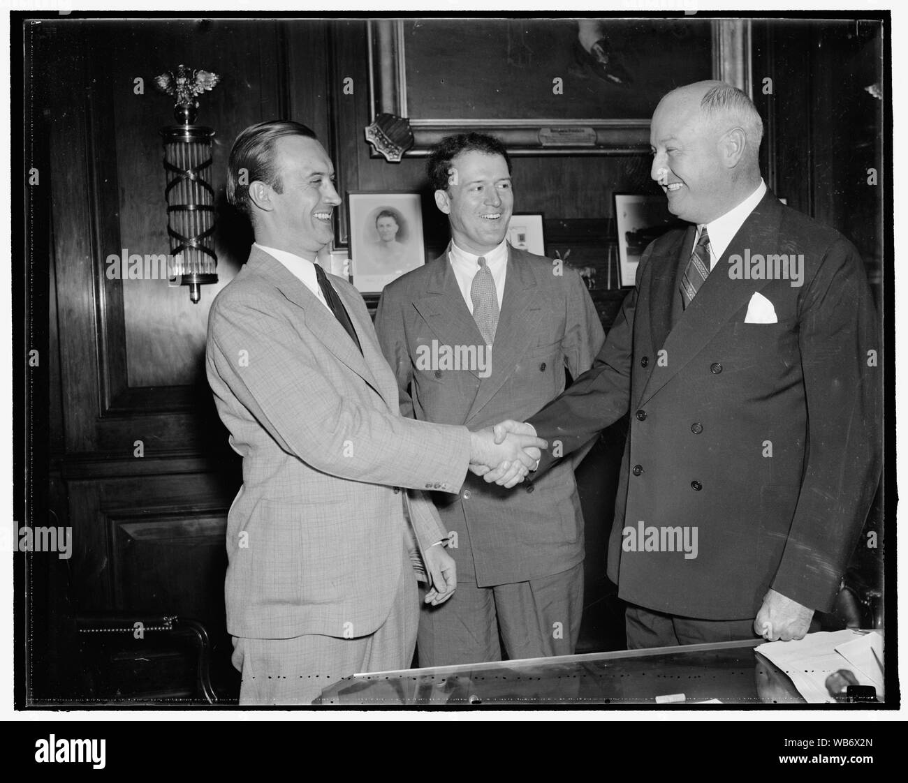 Farley meets new leader of young democrats. Washington, D.C. Aug 25. Newly elected president of the Young Democrats of America, Pitt. T. Maner, shakes hands with Jim Farley, while John P. Kohn, Jr., Maners campaign manager, looks on Abstract/medium: 1 negative : glass ; 4 x 5 in. or smaller Stock Photo