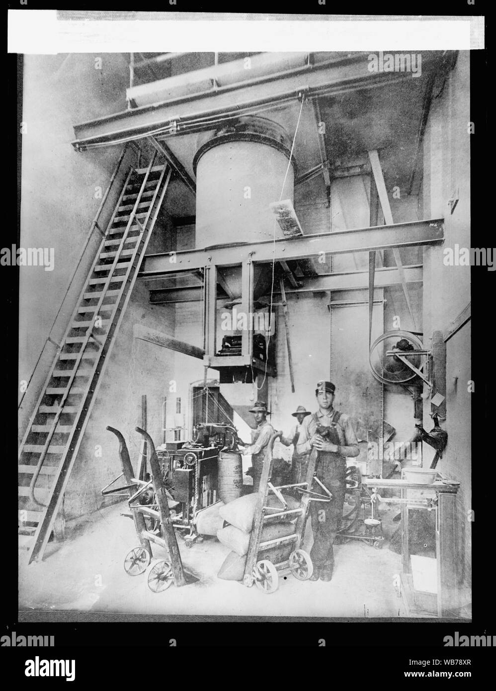 Filling, weighing, and sewing sacks of granulated sugar in a beet sugar factory Abstract/medium: 1 negative : glass ; 8 x 6 in. Stock Photo