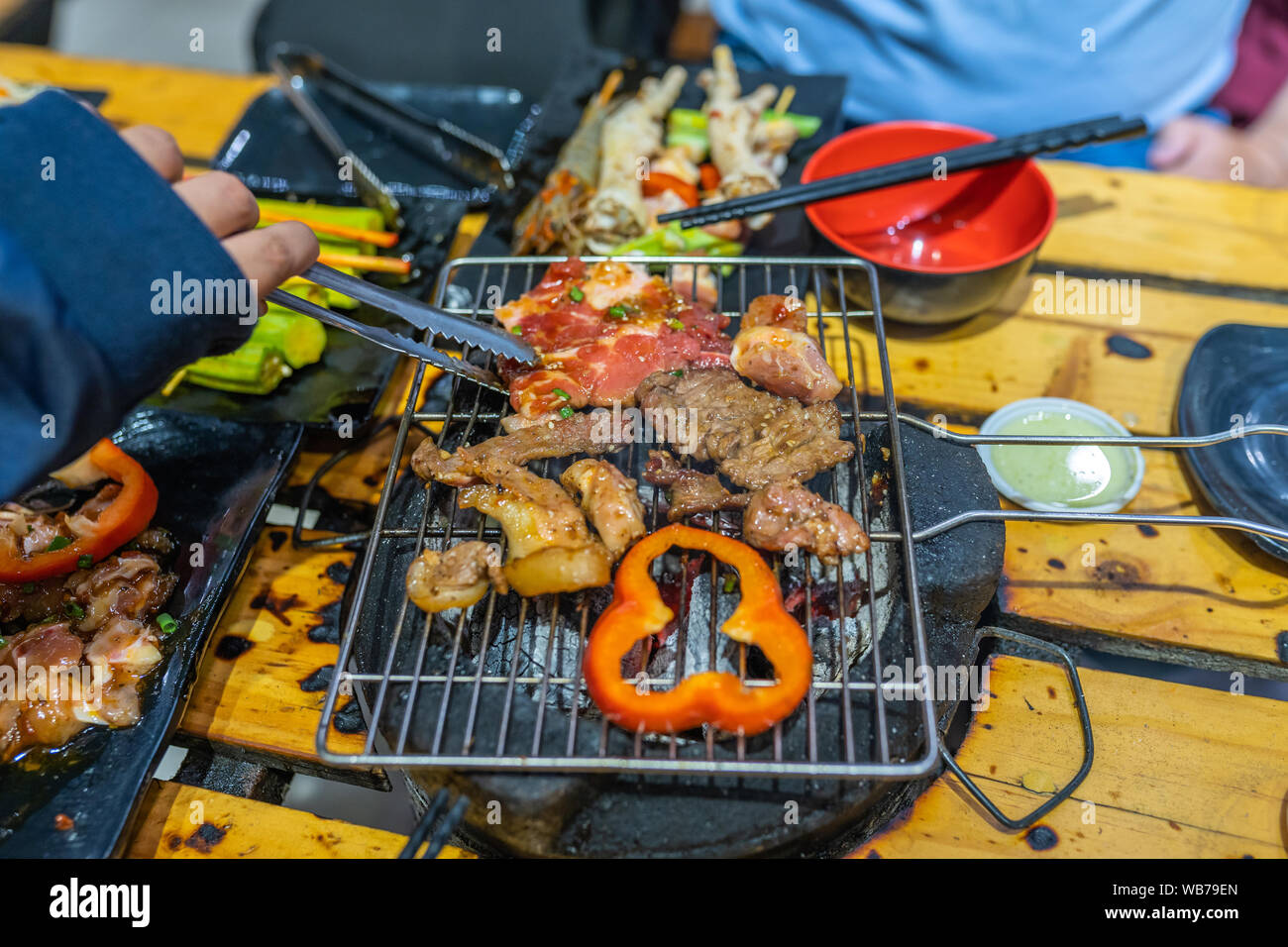 Human hand using tongs and grilling barbecue meat slices Stock Photo - Alamy