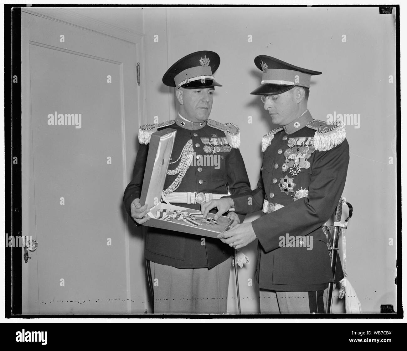 First lady to be decorated by Cuban government. Washington, D.C., Nov. 2. The decoration of the Grand Cross of the Cuban Red Cross which will be presented to Mrs. Franklin D. Roosevelt at the White House Thursday, was brought to the Capital today be Lieut. Col. Evelio Figarola [?], infante [?] (right), General Secretary of the Cuban Red Cross Society and Major Luis Fernandez Ardois, personal aide to Col. Figarola. The decoration is offered to Mrs. Roosevelt in recognition of her humanitarian work and as a token of appreciation from the Cuban Red Cross Society. Cuban Ambassador Fraga will make Stock Photo