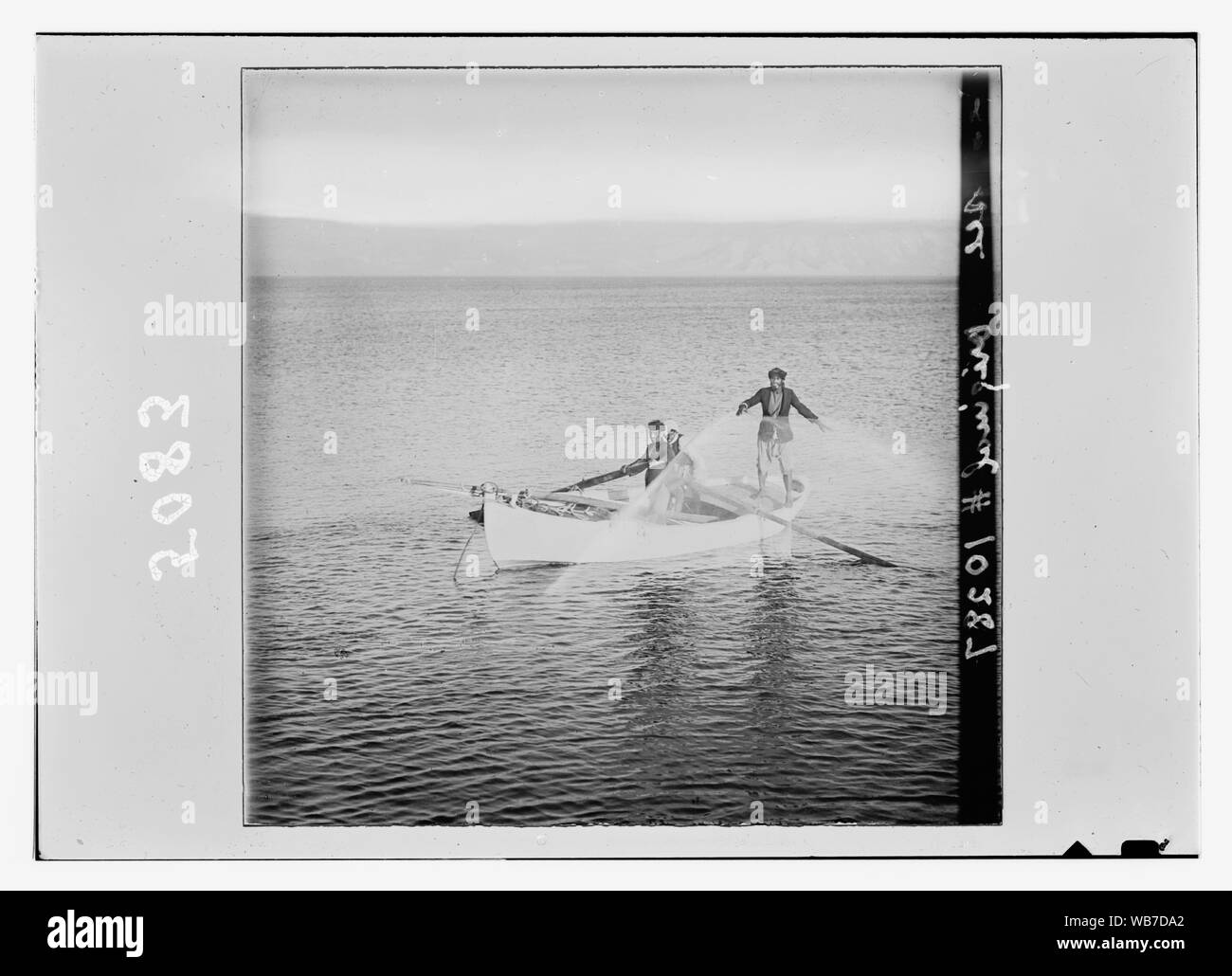 Fishermen on Galilee throwing net from boat Abstract/medium: G. Eric and Edith Matson Photograph Collection Stock Photo