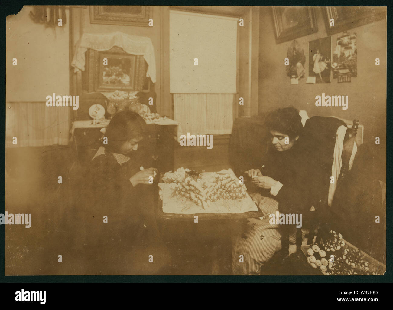 Flower making. A night scene (Photo at 10:30 P.M. and not finished, Jan 29, 1912). Carrie Brindisi,12 years old, 134 1/2 Thompson Street, 2[nd] fl[oor] front. Carries [sic] goes to school. Works after school and nights, Rosie (six years old) helps too. Abstract: Photographs from the records of the National Child Labor Committee (U.S.) Stock Photo