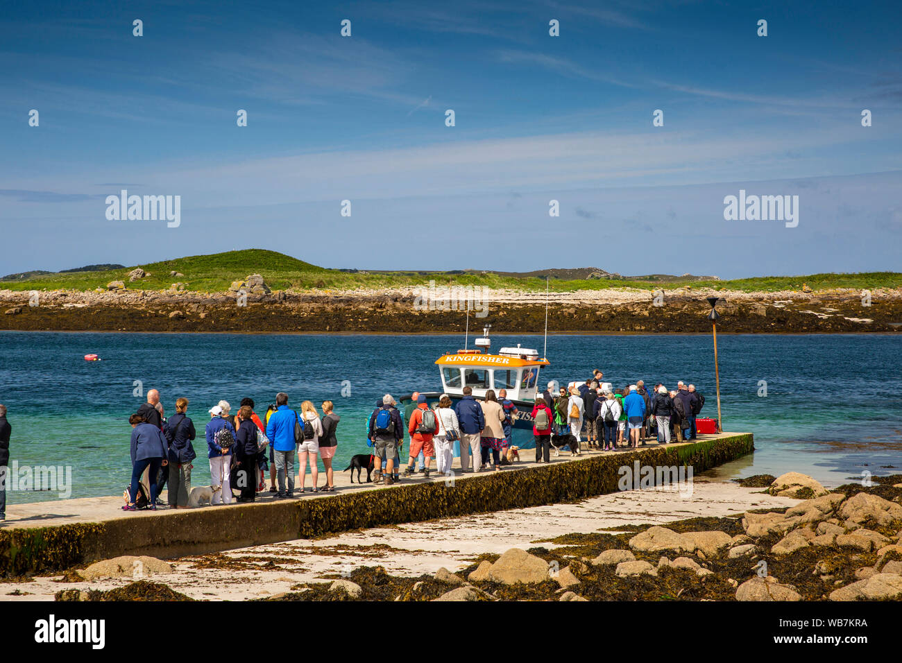 UK, England, Scilly Islands, St Martin’s, Lower Town Harbour, passengers queueing on quay to board inter-island boat Kingfisher Stock Photo