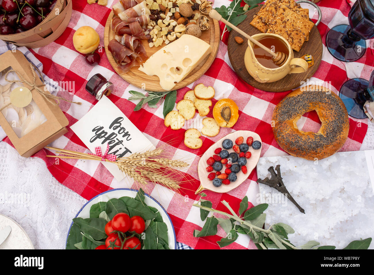 Checkered picnic blanket in french style with foods and sign says bon