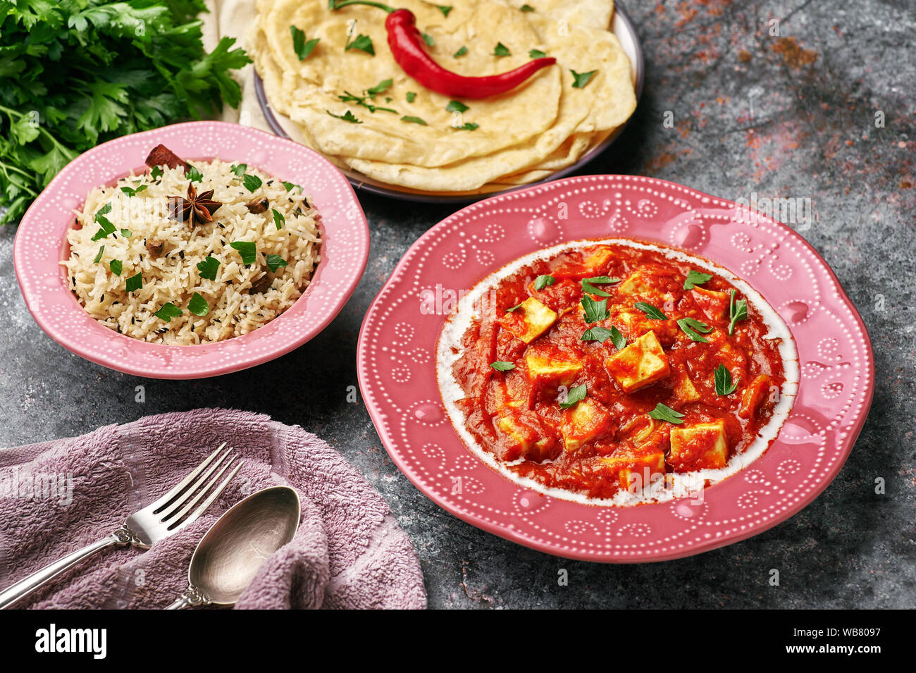 Paneer Makhani, Jeera Rice and paratha in pink plate on dark background