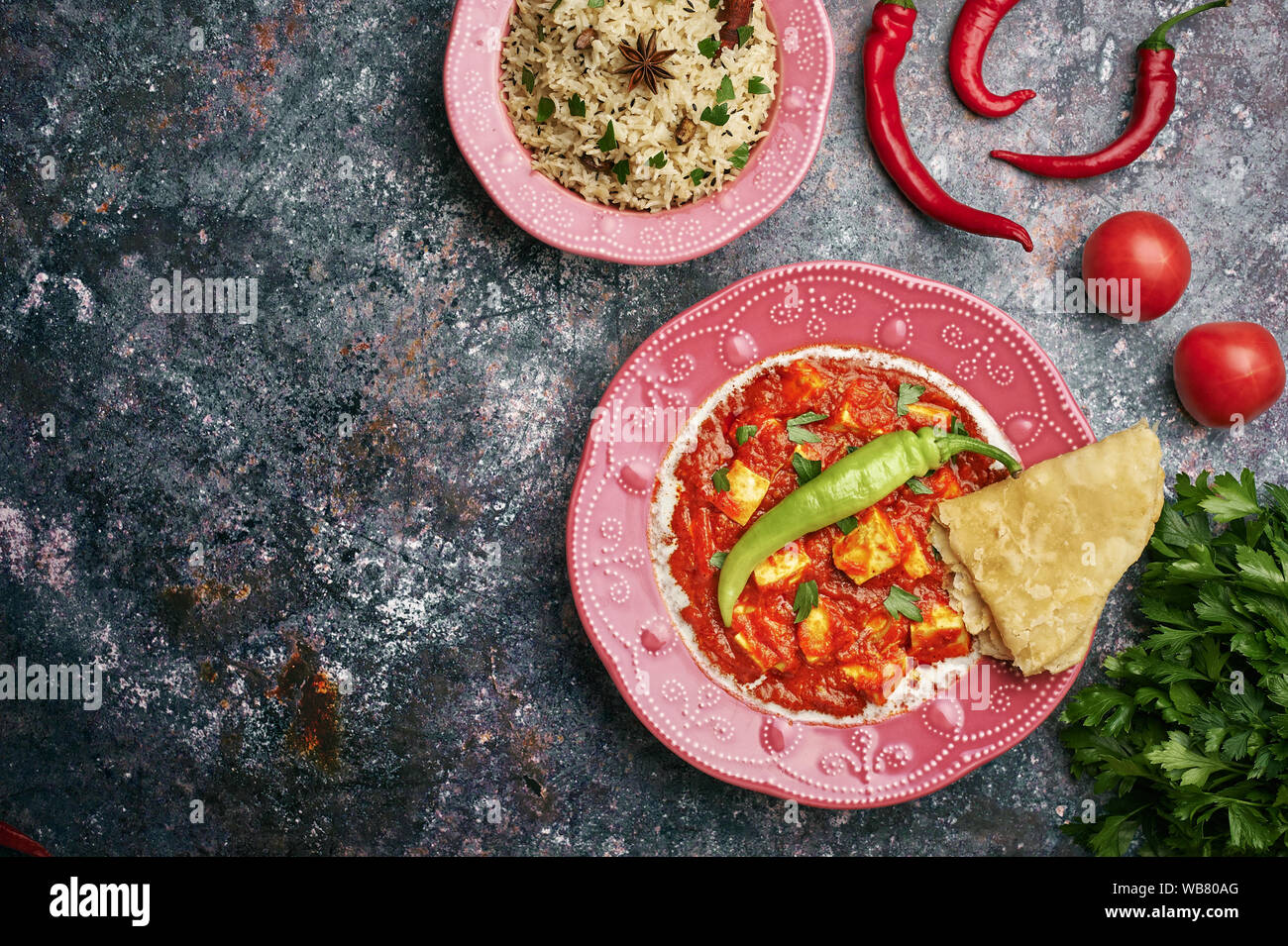 Paneer Makhani, Jeera Rice and paratha in pink plate on dark background